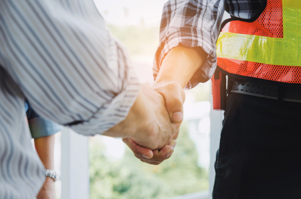 two men in construction shaking hands