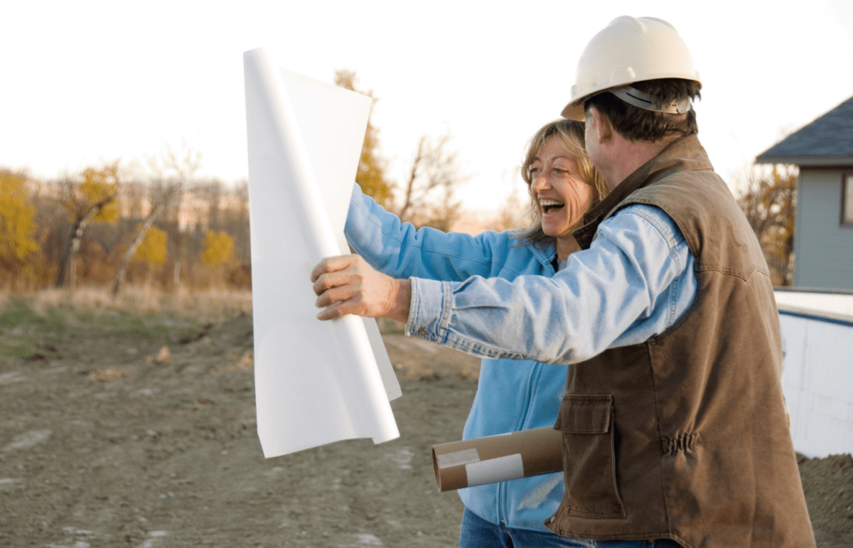 Image of a contractor showing an excited client a house plan- Why Design Build is the Budget Friendly Choice blog featured image