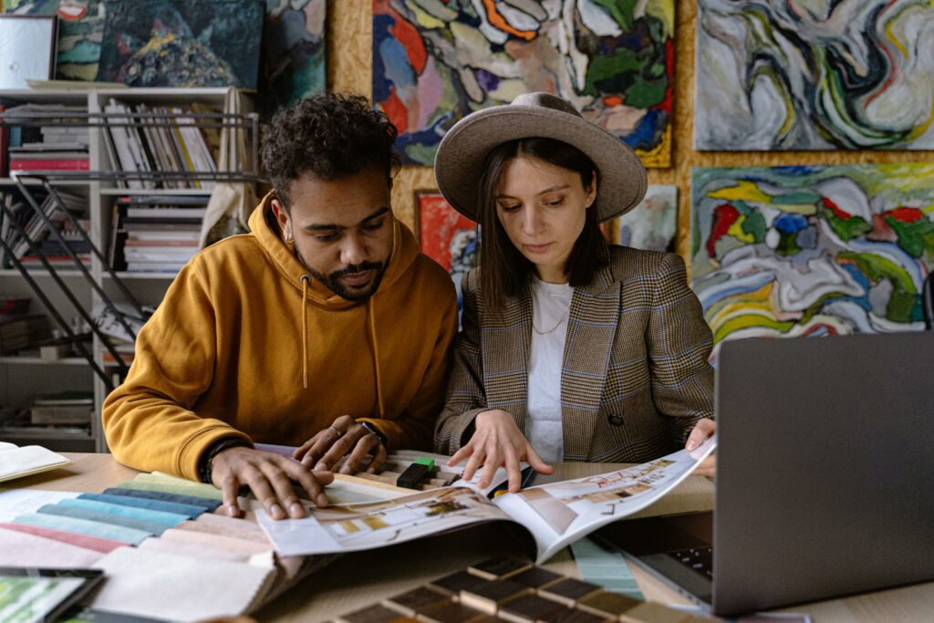 Image of a man and a woman reviewing a portfolio/design book