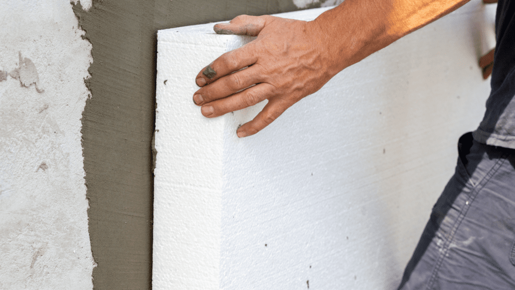 Image of someone installing foam board insulation to an exterior wall.