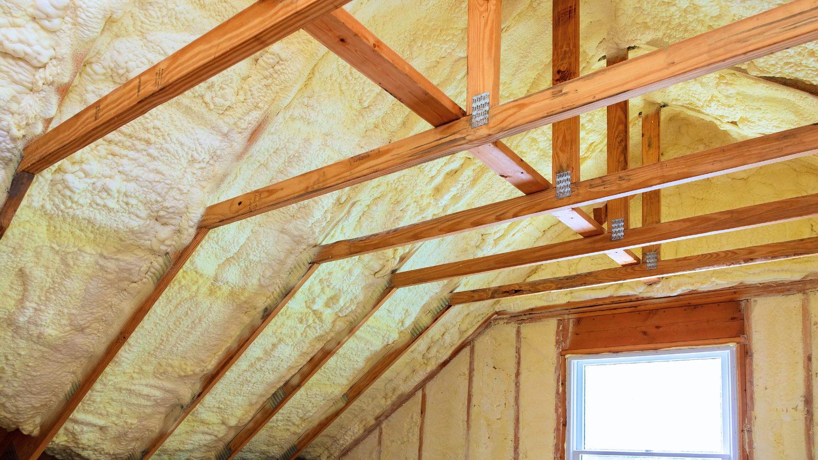 Image of an attic space with spray foam insulation- Best Home Insulation for Attics blog featured image